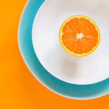 an orange on a white plate